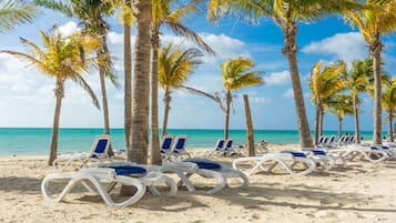 On the beach, white sand, sun loungers, beach umbrellas