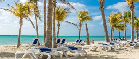 Plage, sable blanc, chaises longues, parasols