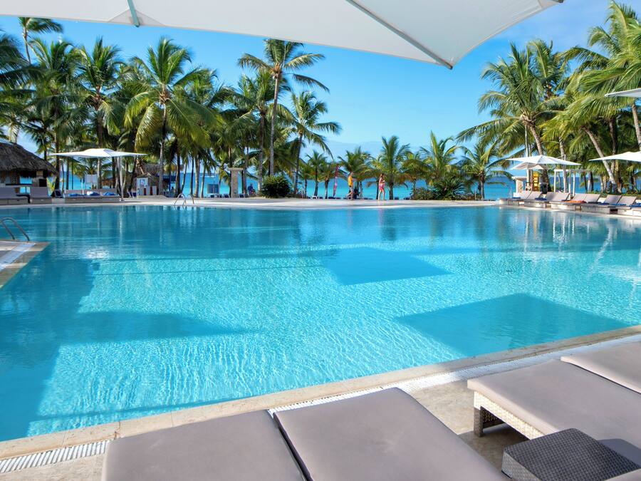 Una piscina al aire libre, sombrillas, tumbonas