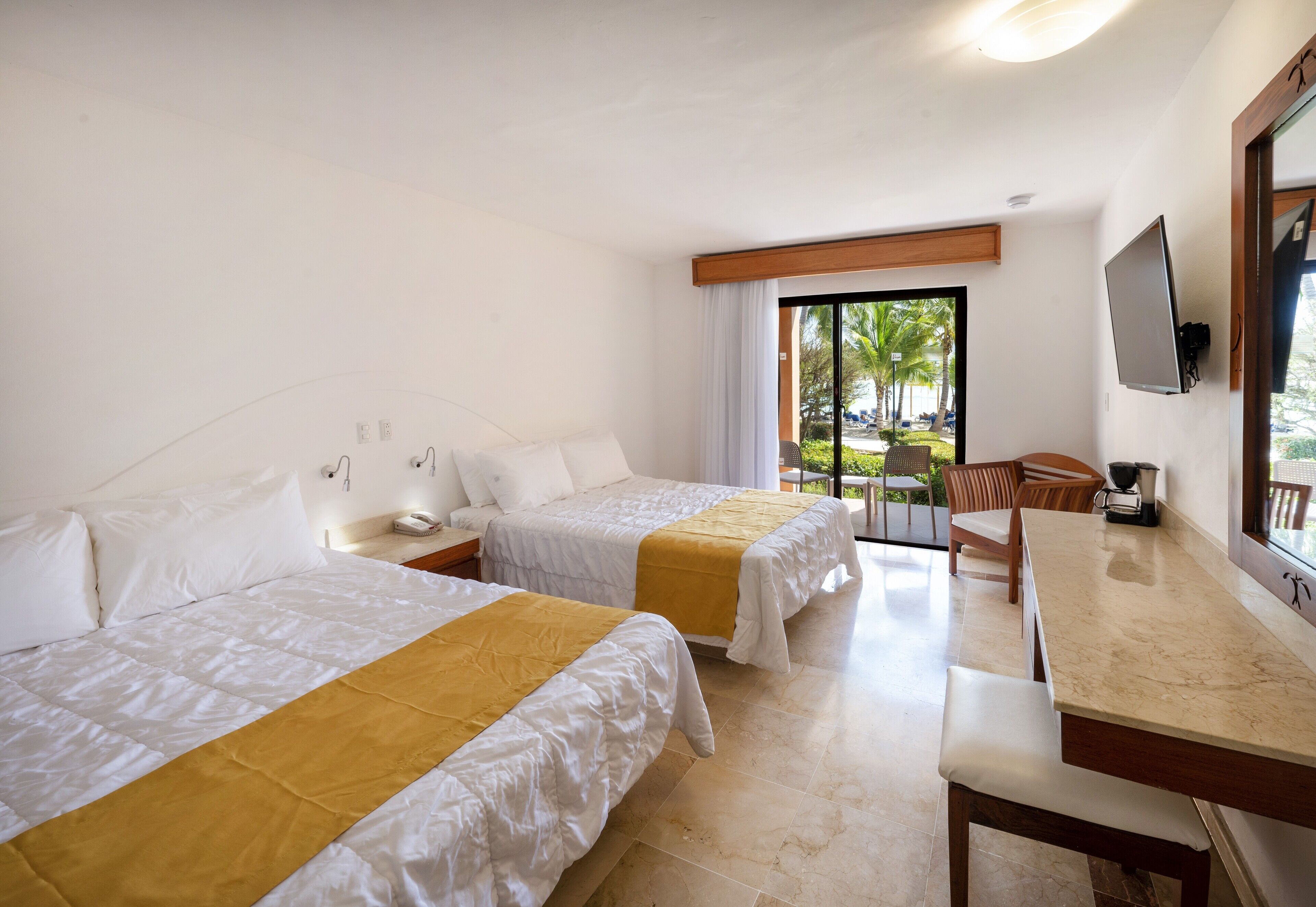 Une chambre d’hôtel avec deux lits, une table à manger, un téléviseur et une vue sur l’extérieur.