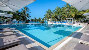 Una piscina al aire libre, sombrillas, tumbonas