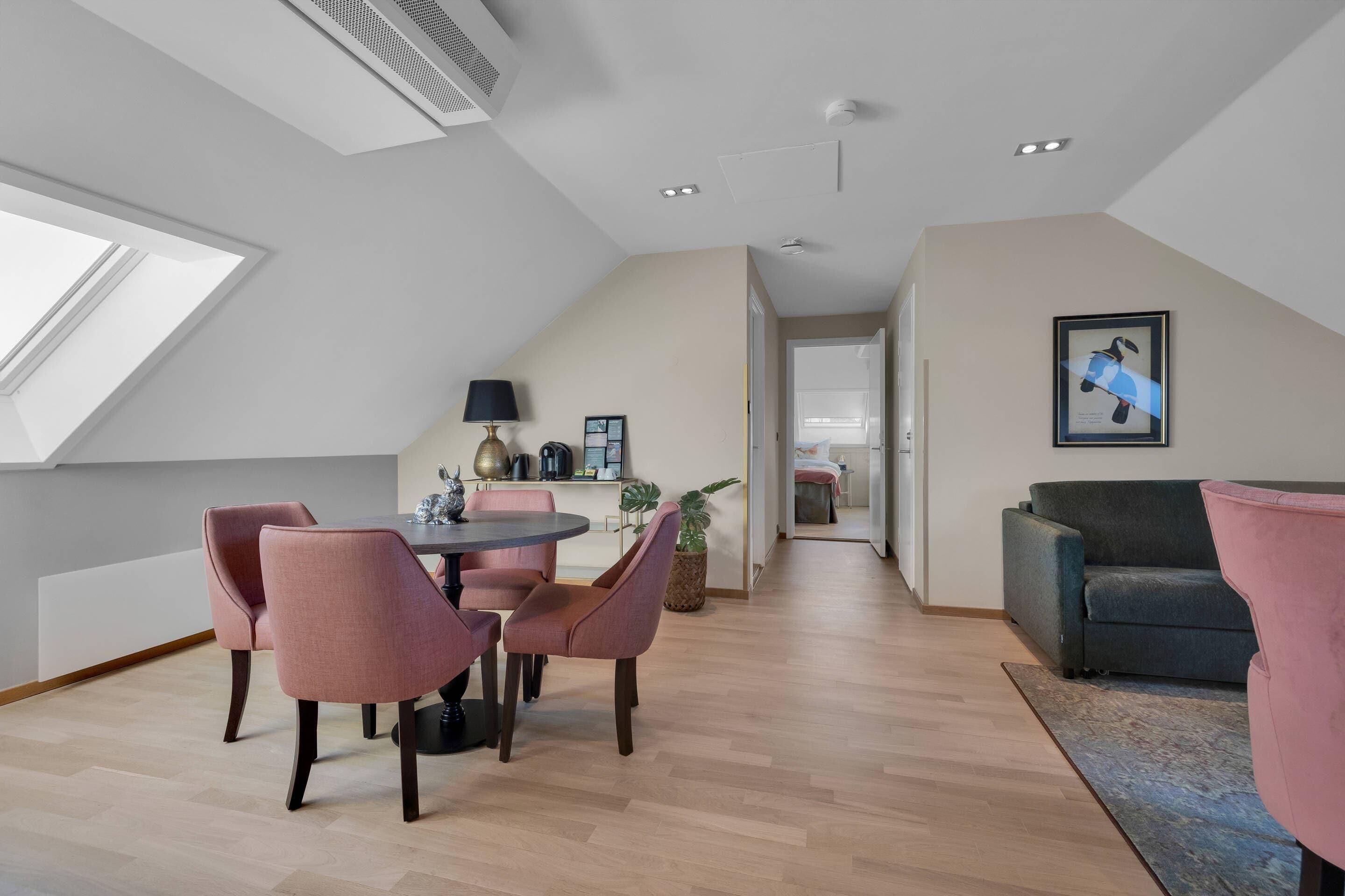 Un espace de vie moderne de style loft, comprenant un coin repas, un canapé et une grande fenêtre.