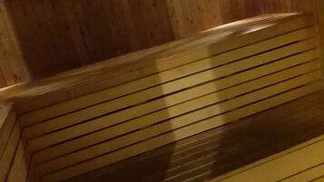 Una sauna de madera con bancos y paredes con listones.