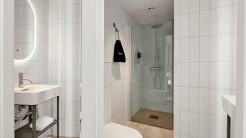 Ein modernes Badezimmer mit einem weißen Waschbecken, einer Toilette, einer Duschkabine und einem Handtuchhalter mit einer schwarzen Tasche.