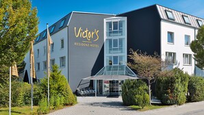 Un moderno edificio de hotel con una entrada destacada, fachada de vidrio y un letrero que dice 