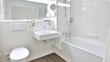 A modern bathroom with a toilet, sink, and bathtub.
