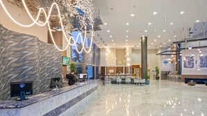 A spacious lobby with a reception desk, seating area, and decorative elements. - Sol Costa Daurada (Salou)