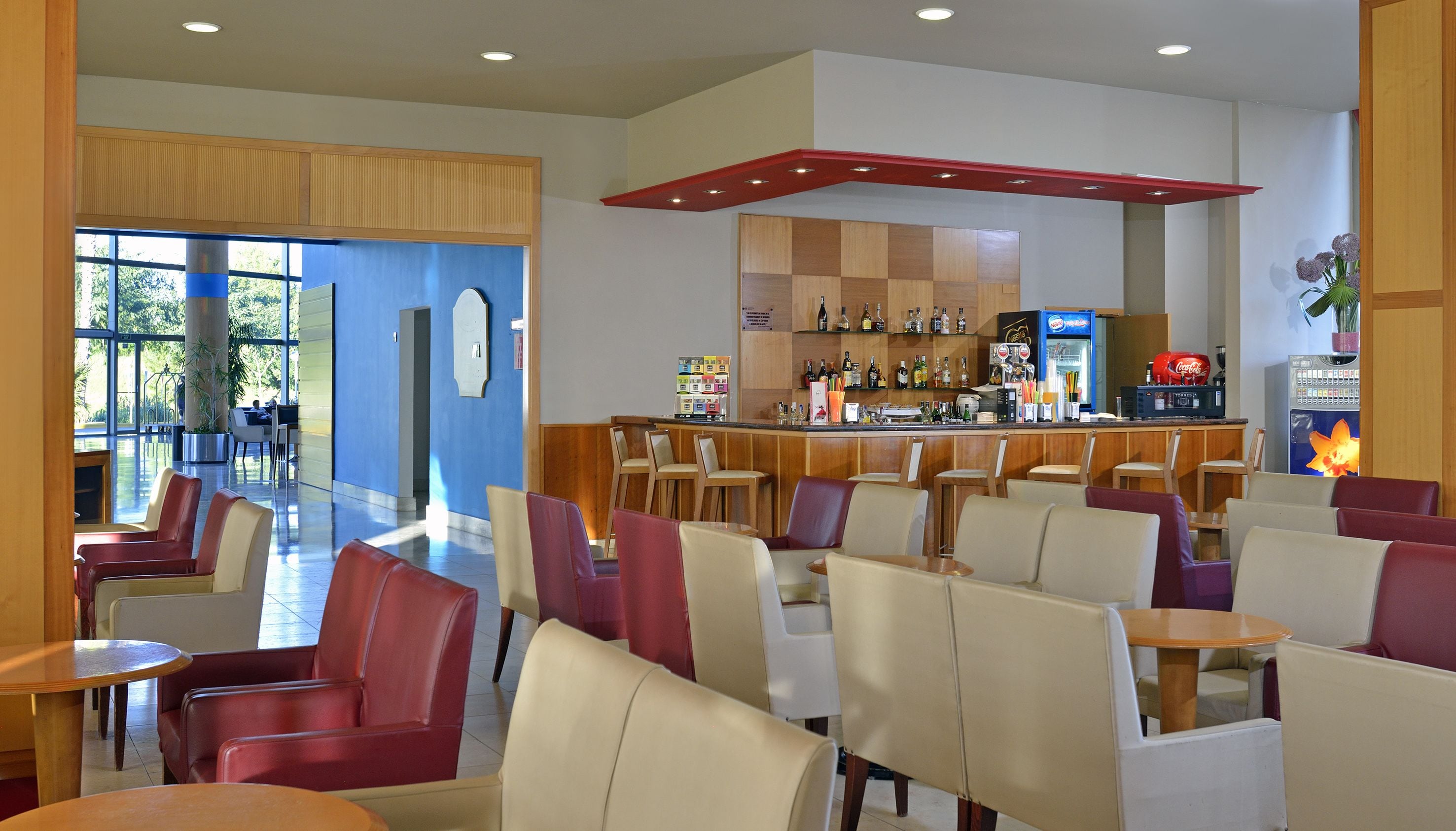 A modern bar area with seating and a variety of beverages.