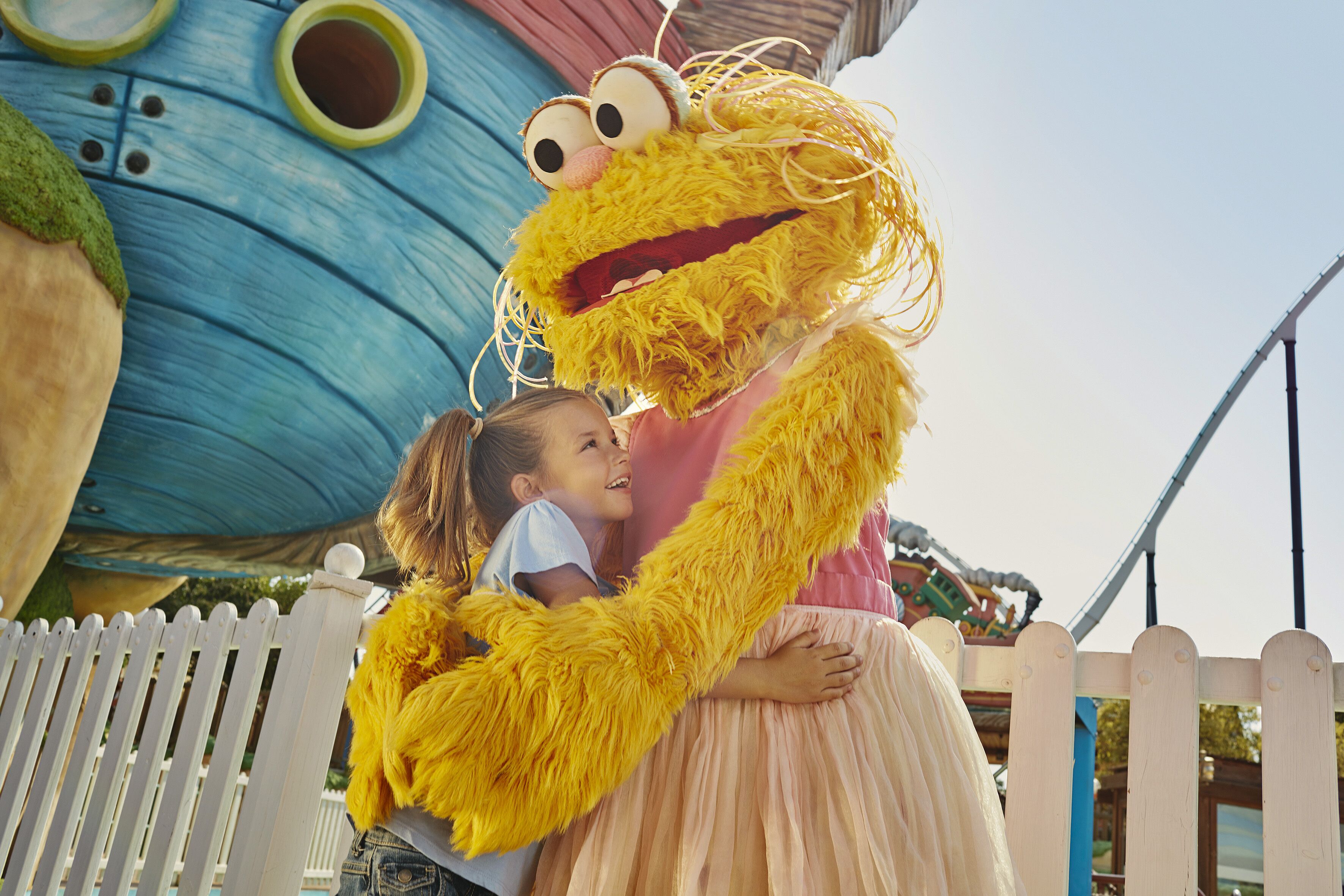 A person in a yellow costume hugging a child.