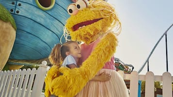 A person in a yellow costume hugging a child.