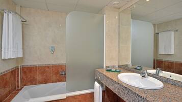 Un bany amb dutxa, un lavabo i un mirall.