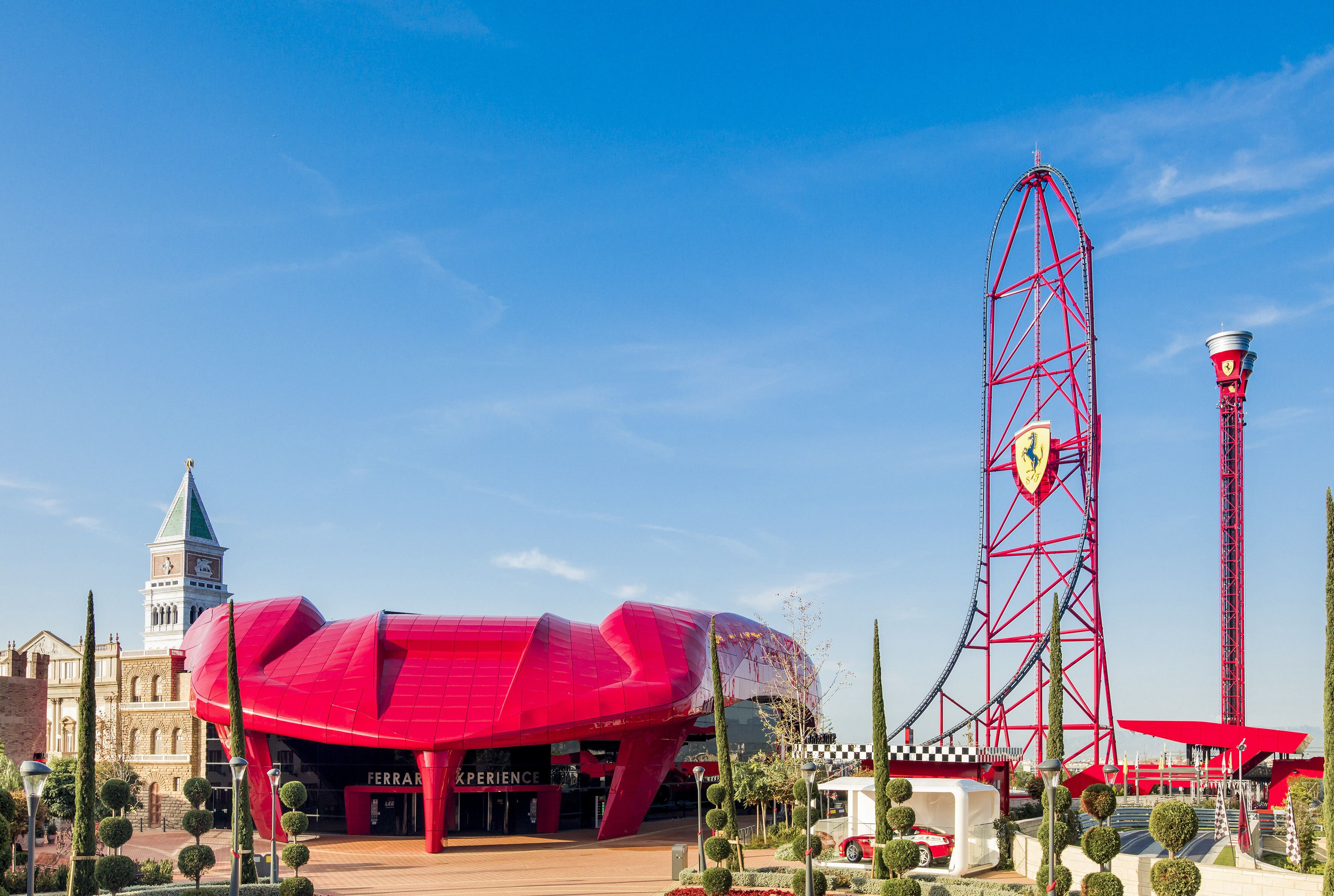 Ein Riesenrad und ein rotes Gebäude mit einem Glockenturm.