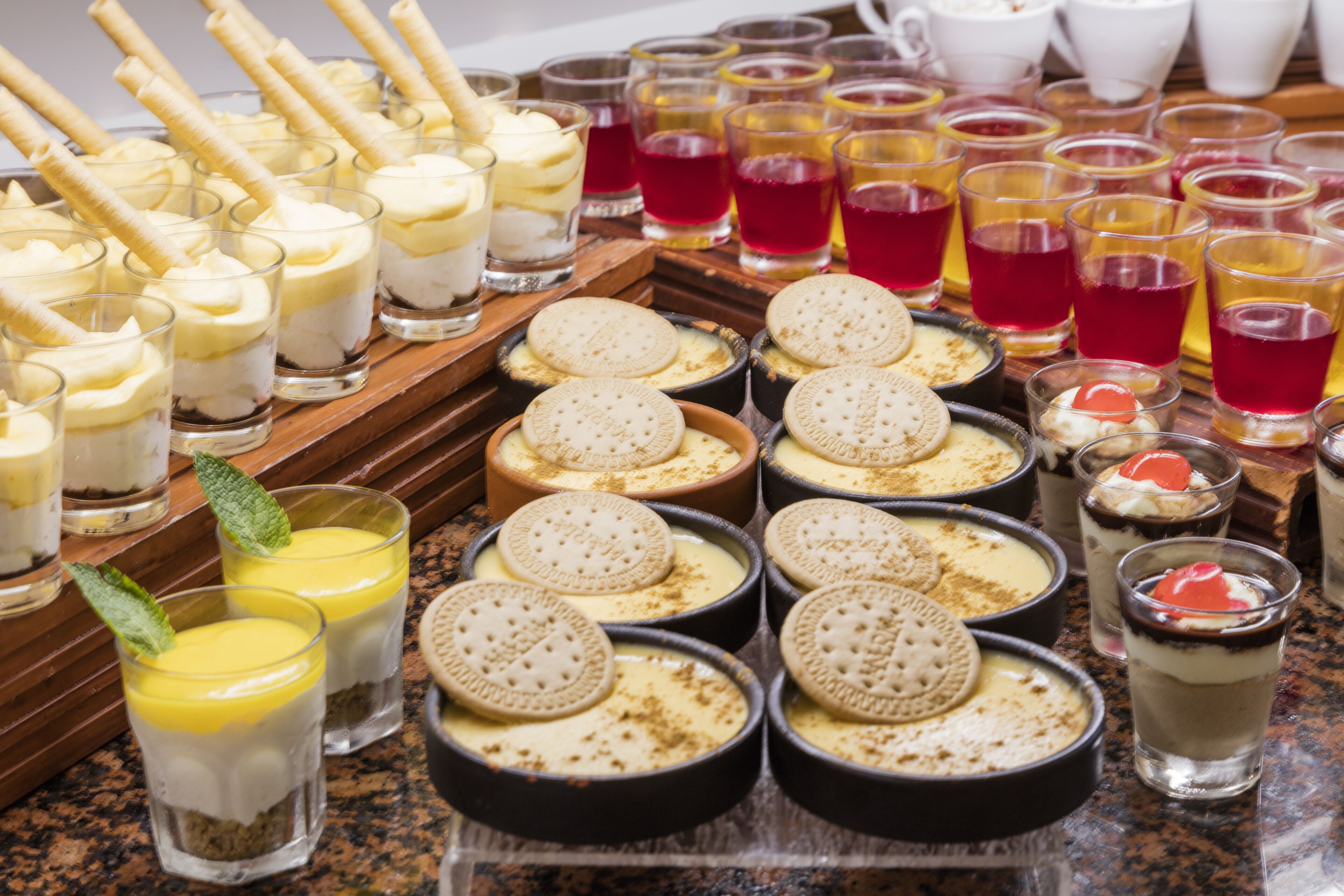 A variety of desserts and beverages on a buffet table.