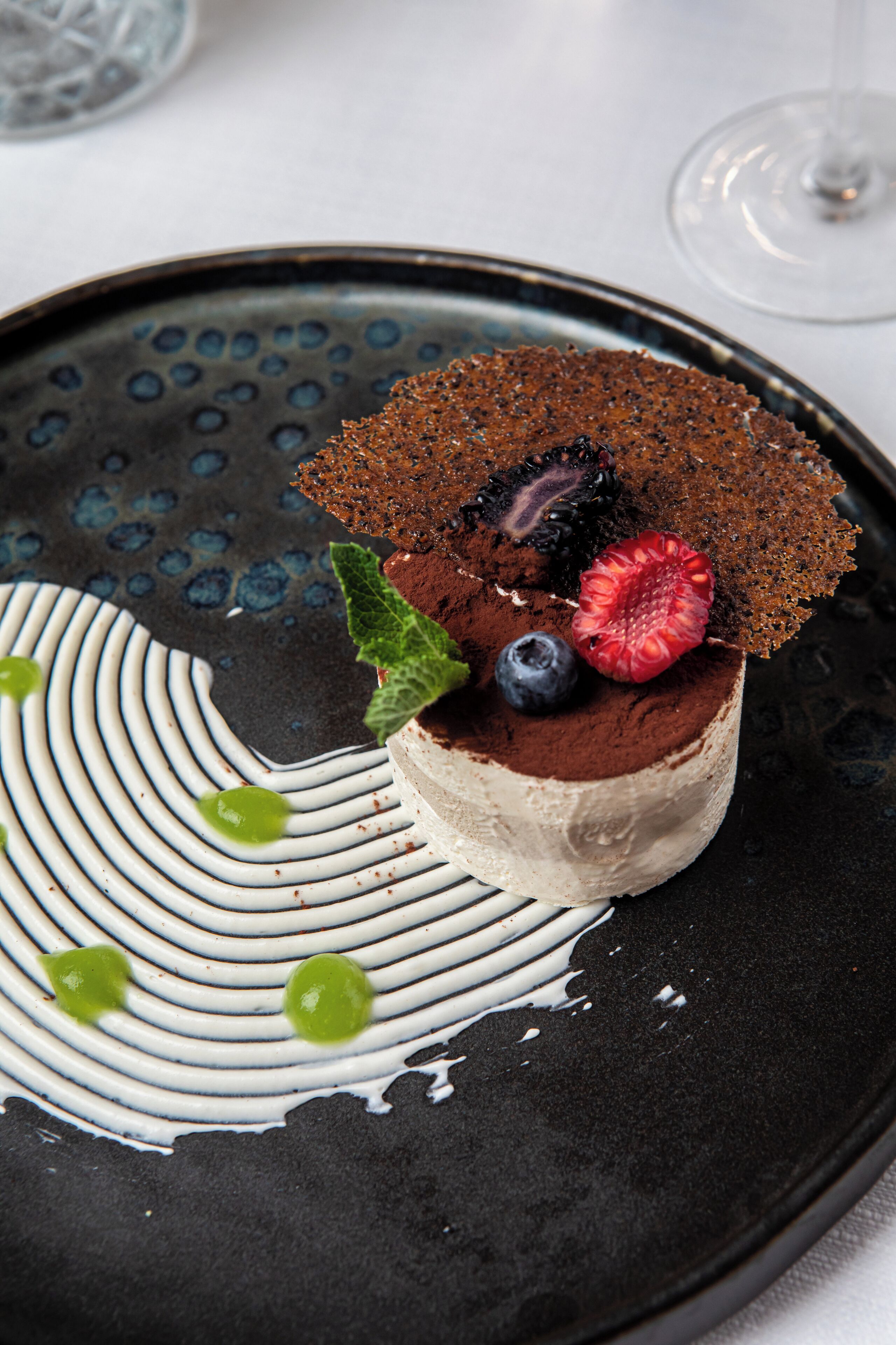 Un dessert présenté dans une assiette au design original, en noir et blanc.