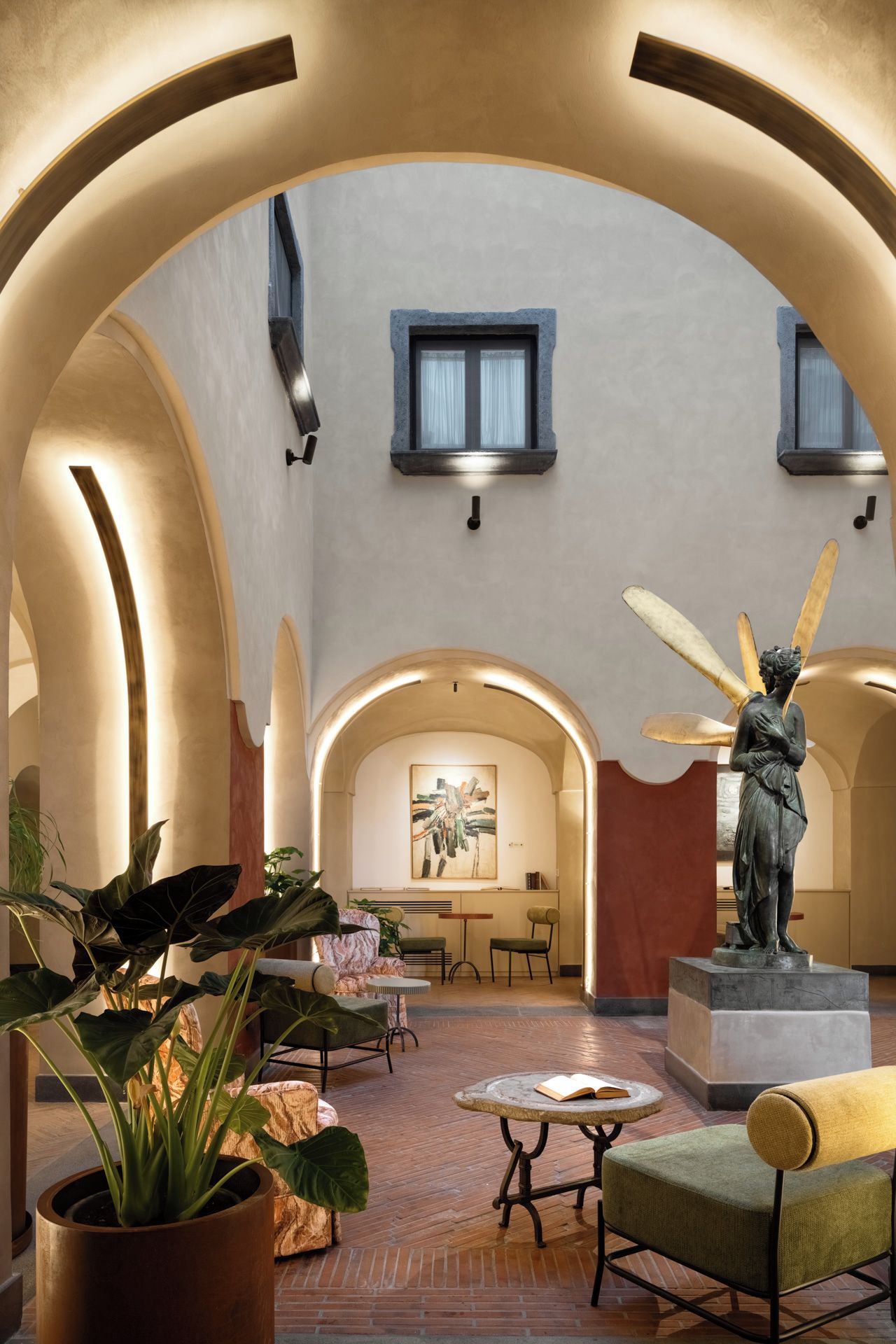 A spacious interior with arched ceilings, a statue, and a dining area.