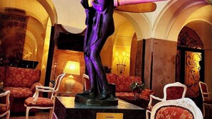 Eine Statue in einer Lobby mit rot gepolsterten Sesseln und einer Lampe.