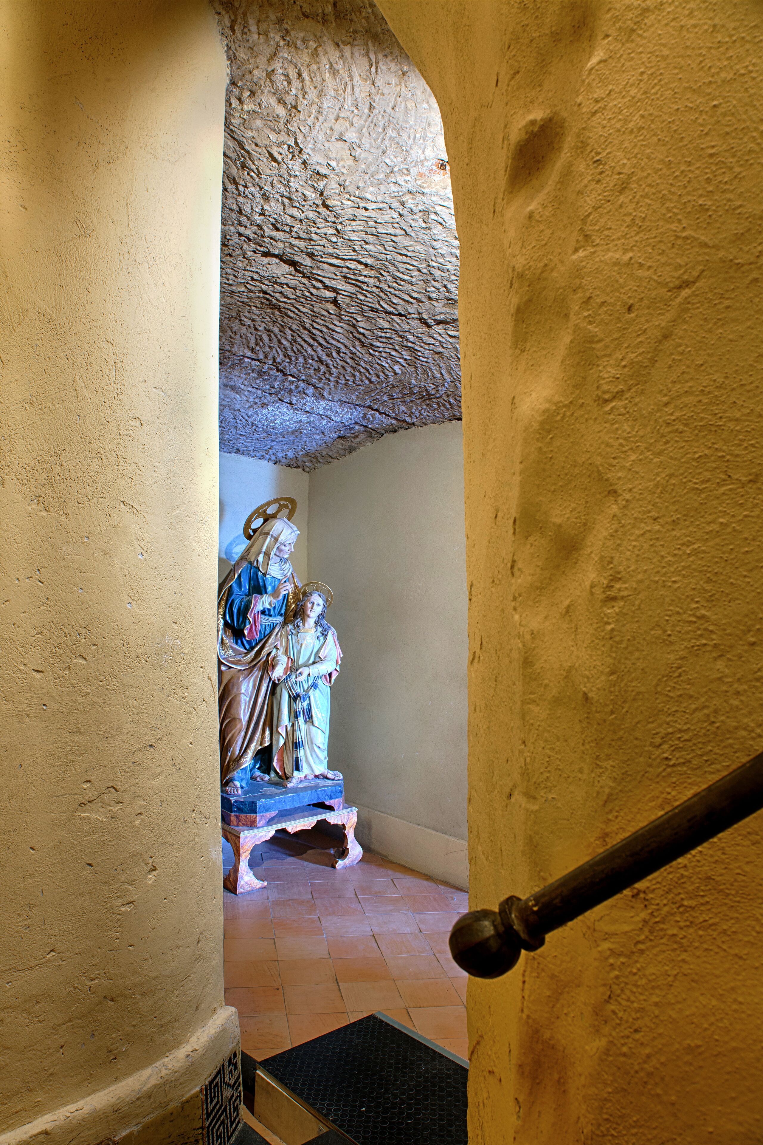 A staircase with a statue of a religious figure at the top.