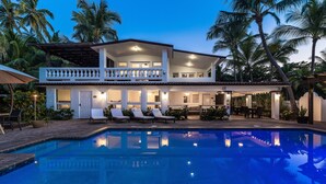 A two-story house with a swimming pool, outdoor seating, and palm trees. - Casa Isleña Inn (Rincon)