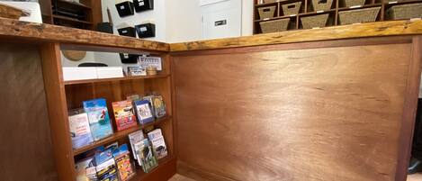 A reception area with a wooden reception desk, shelves with brochures and a 'Beachfront Massage' sign.
