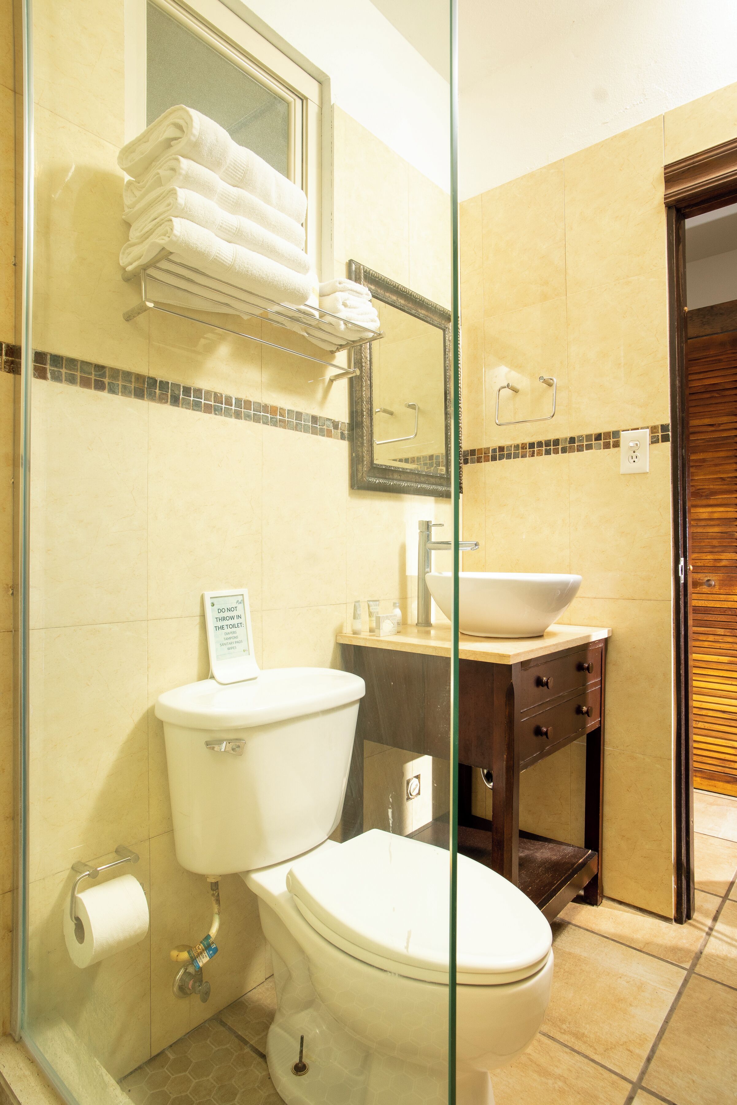 Een badkamer met toilet, wastafel en handdoekhouder.
