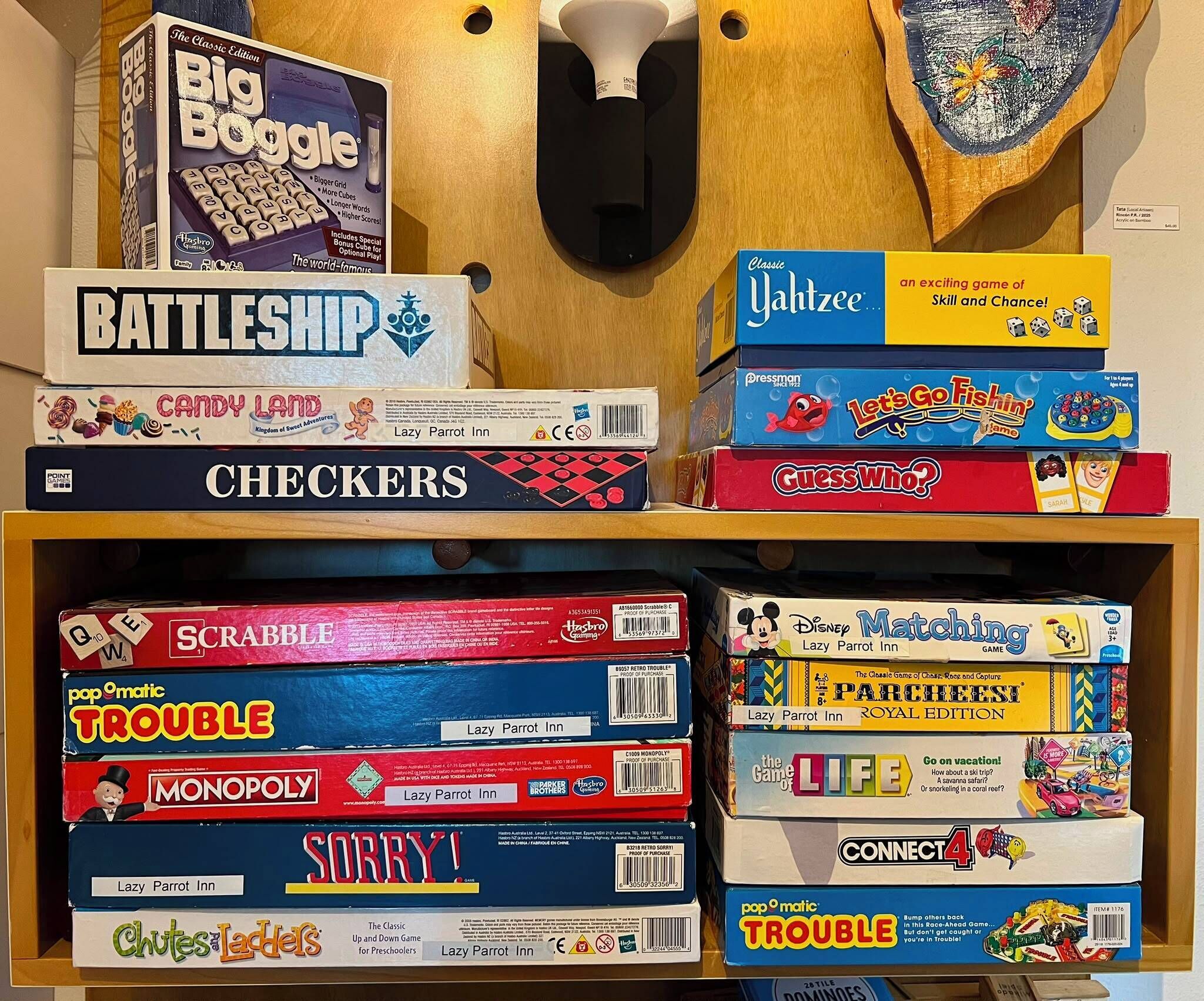 Une étagère contenant divers jeux de société, notamment le jeu de guerre, Candy Land, les dames, Scrabble, Monopoly et d’autres.