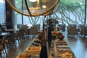 A buffet setup with various food items and a central decorative vase.