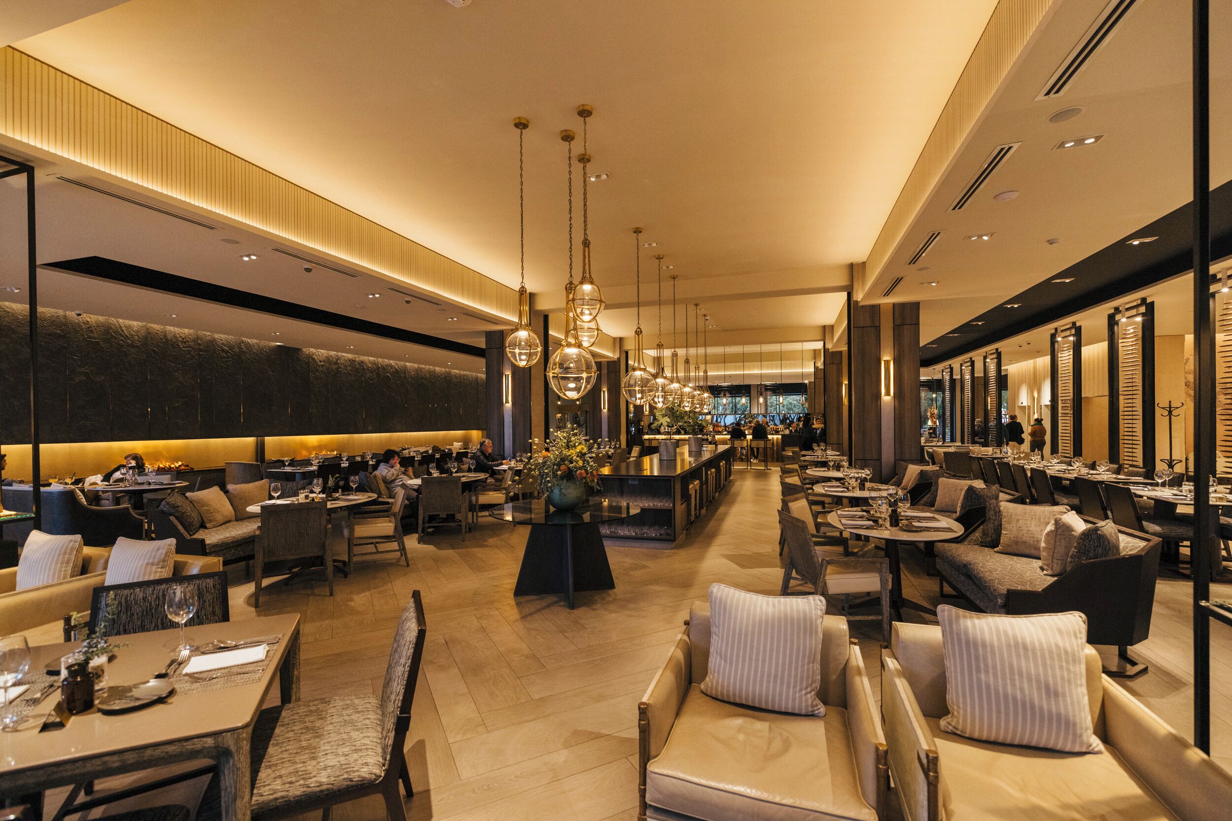 A spacious hotel lobby with multiple seating areas, a central bar, and a modern design.