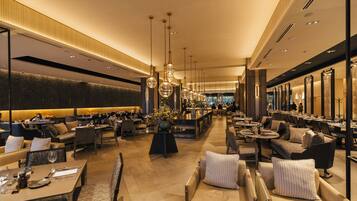 A spacious hotel lobby with multiple seating areas, a central bar, and a modern design.