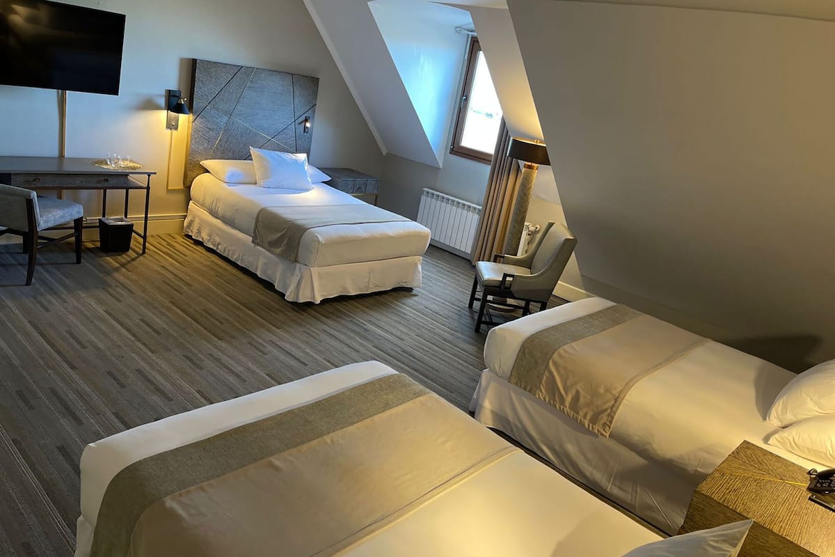Ein modernes Hotelzimmer mit einer Schlafgalerie, einem Bett, einem Schreibtisch und einem Stuhl.