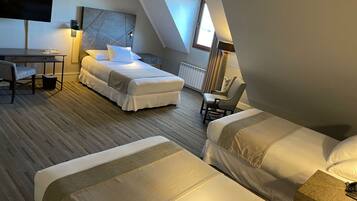 A modern hotel room with a loft-style ceiling, a bed, a desk, and a chair.