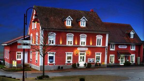 A red building with a sign for a restaurant and a reception area. - Hotel Zur Tanne (Fischingen)
