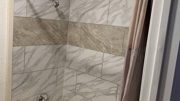 Un baño con bañera, ducha y váter.