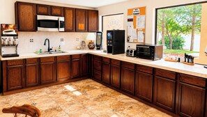 A kitchen with wooden cabinets, a microwave, a coffee machine, and a toaster. - Ticaboo Lodge (Ticaboo)