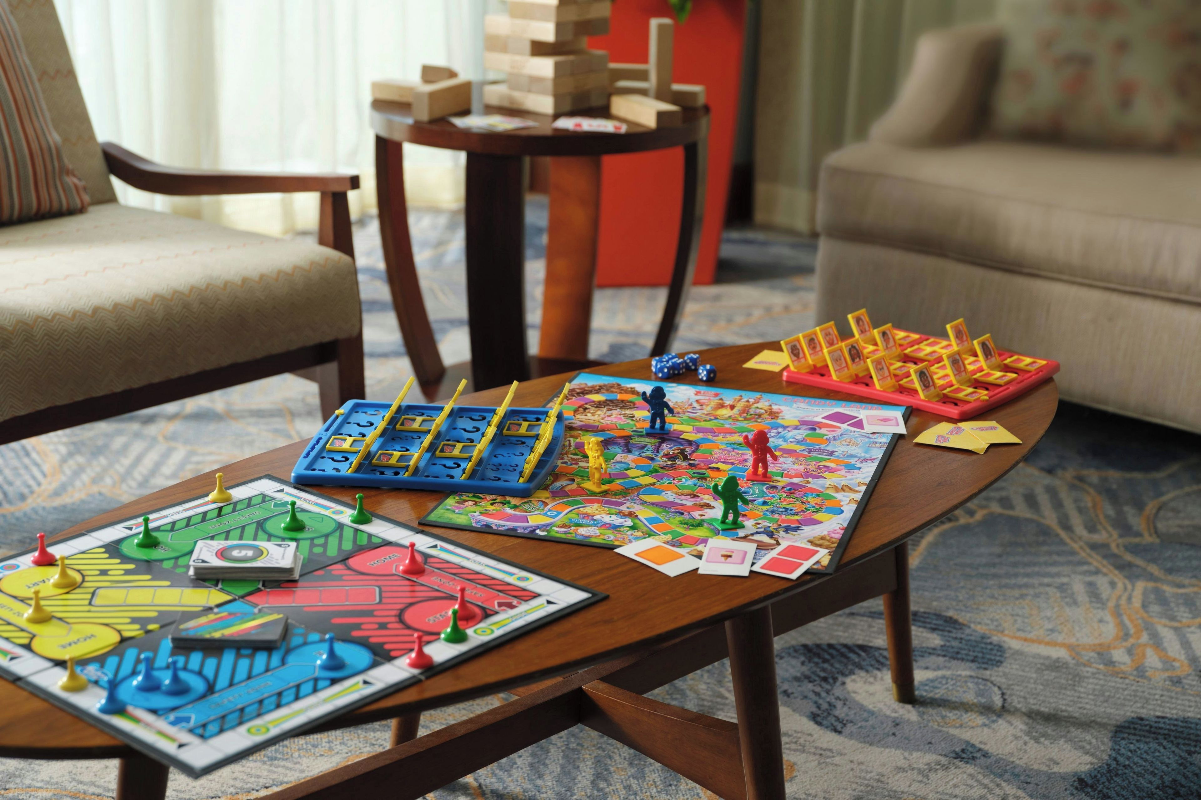 A wooden coffee table with various board games and game pieces.
