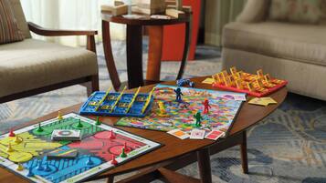 A wooden coffee table with various board games and game pieces.