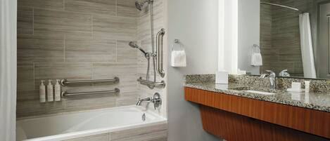 A modern bathroom with a bathtub, shower, and vanity.