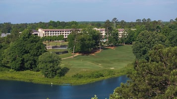 Campo de golfe com um edifício ao fundo.