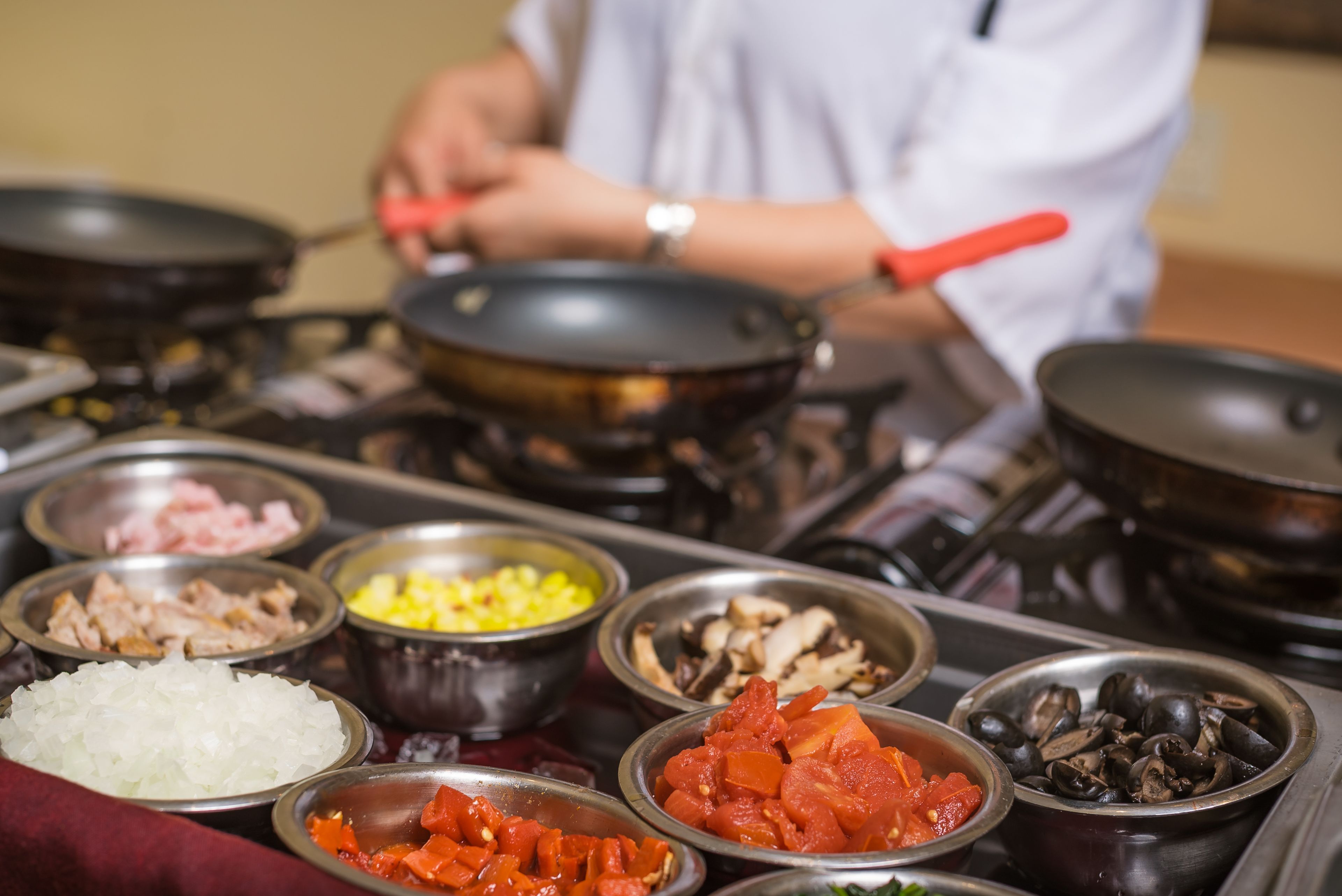 A buffet with various food items in bowls, including meats, vegetables, and seafood.