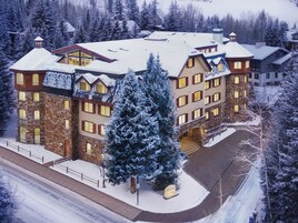 Un grande hotel a più piani con tetto innevato e numerose finestre.