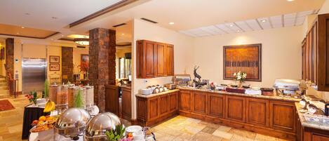Una cocina amplia con armarios de madera, encimera de granito y espacio para desayuno tipo buffet.