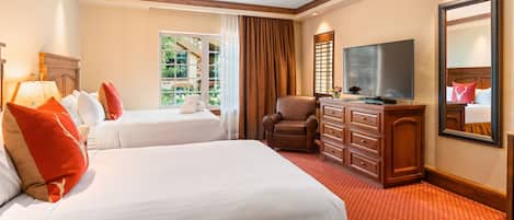 A hotel room with two beds, a TV, a chair, and a dresser.