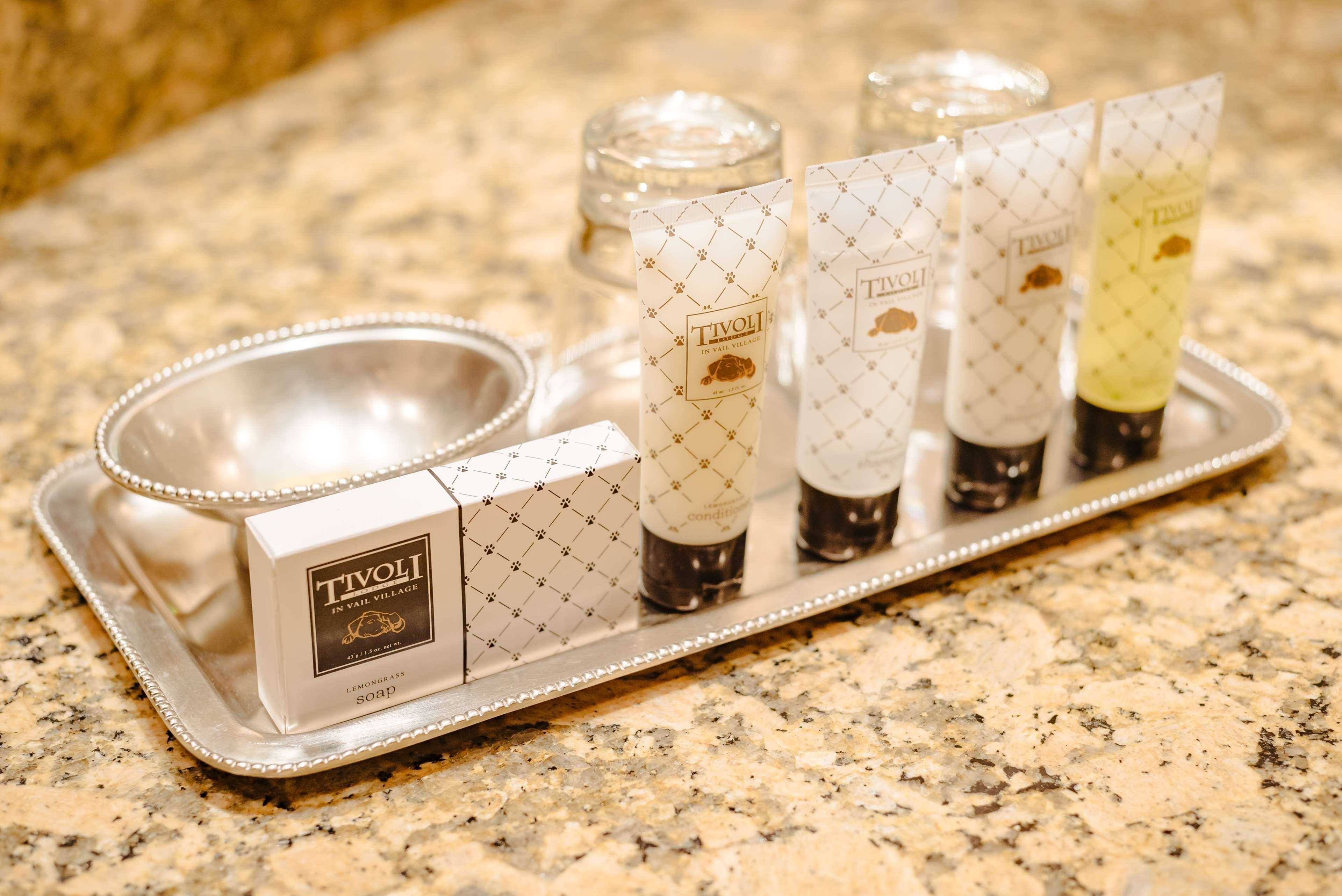A tray with six bottles of Tivoli in Vail Village soap, a silver bowl, and a silver tray.