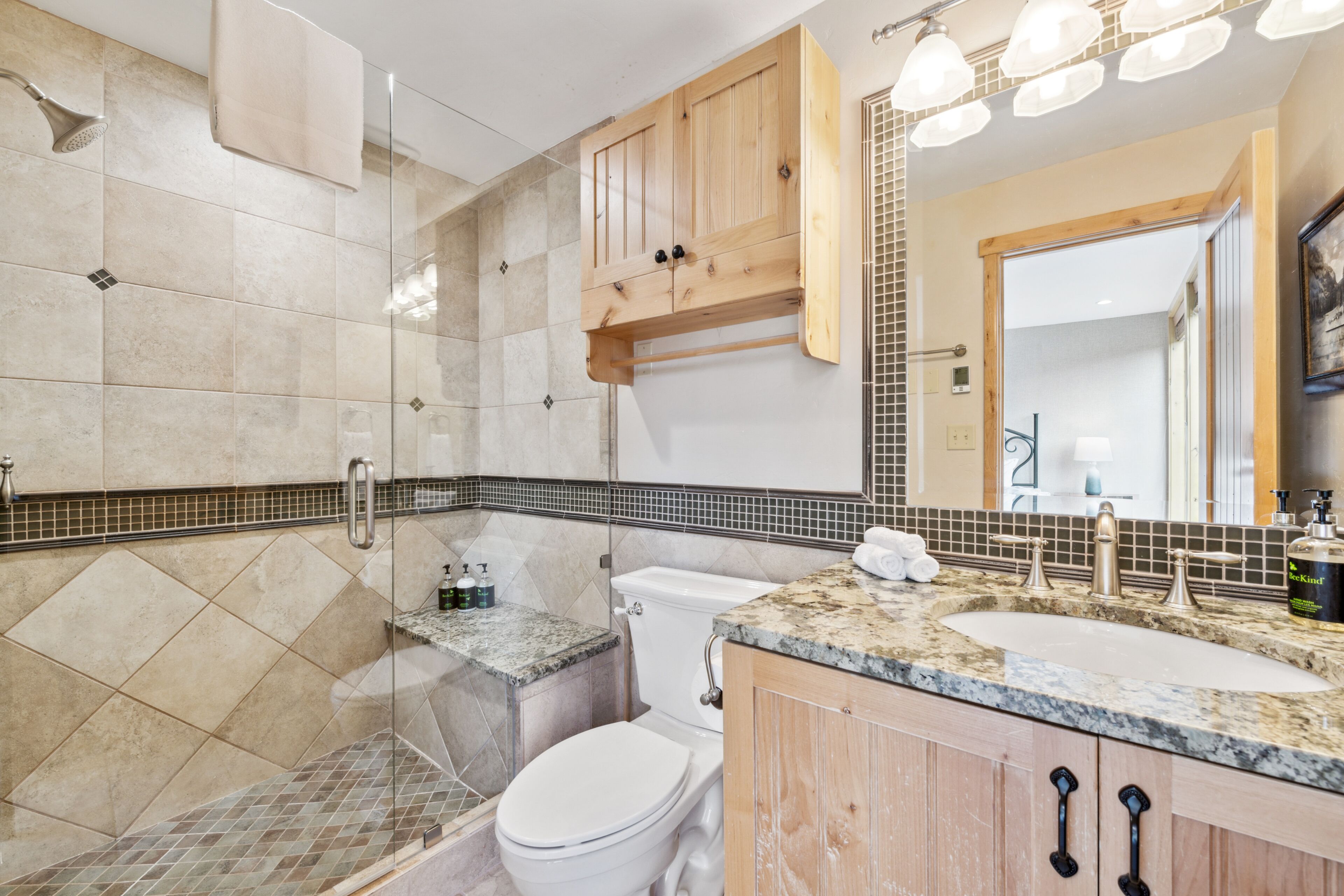 Une salle de bain équipée d’une douche, de toilettes, d’un lavabo et d’un meuble-lavabo.