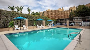 Een buitenzwembad, parasols voor strand/zwembad