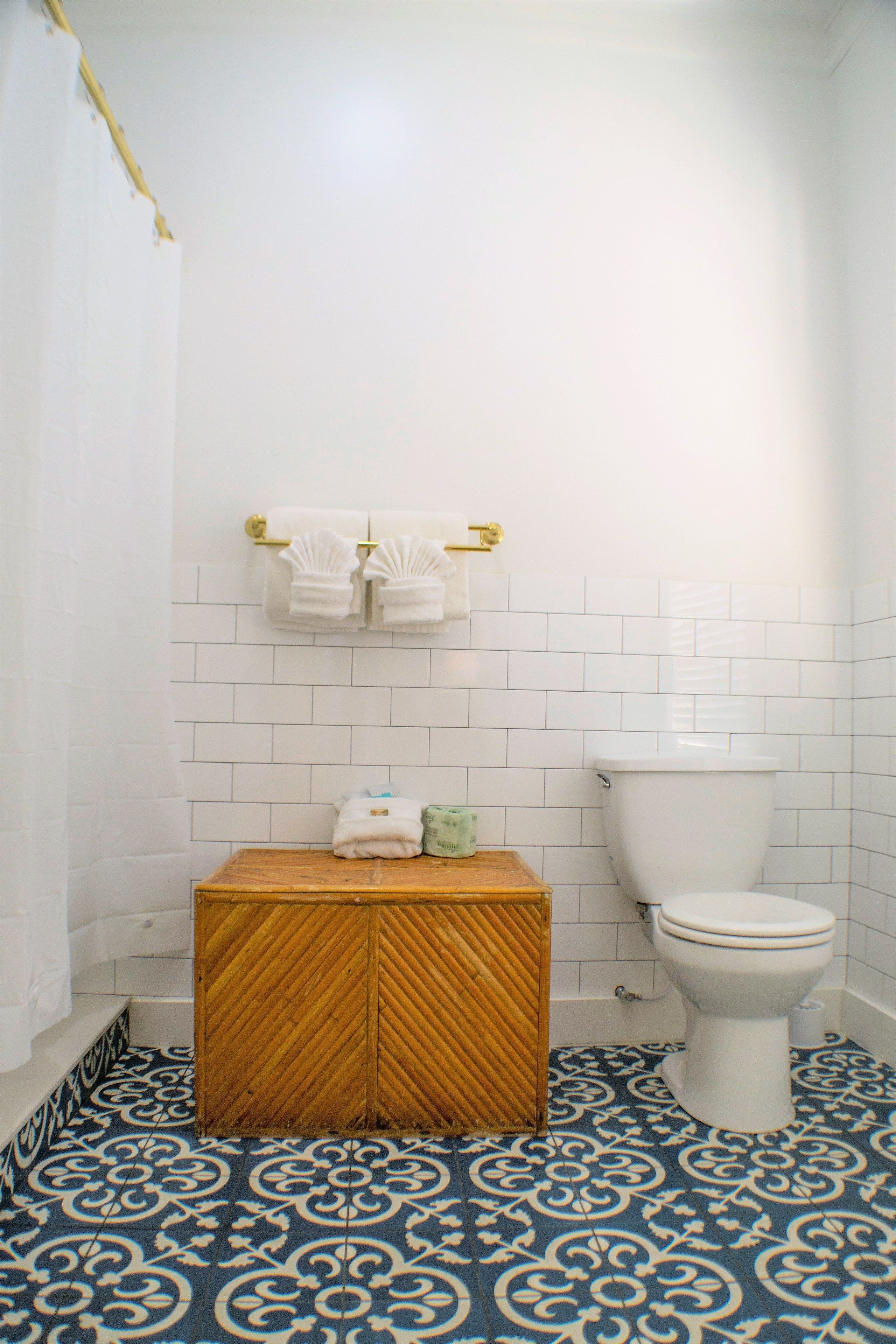 Un baño con inodoro, un armario de madera y piso estampado.