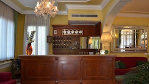 A well-appointed lobby with a wooden reception desk, a chandelier, and a red sofa. - Hotel Villa Cipro (Venice)