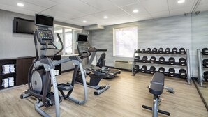 A gym with treadmills, an elliptical, a bench press, and a rack of dumbbells. - Fairfield Inn by Marriott Toronto Oakville (Oakville)
