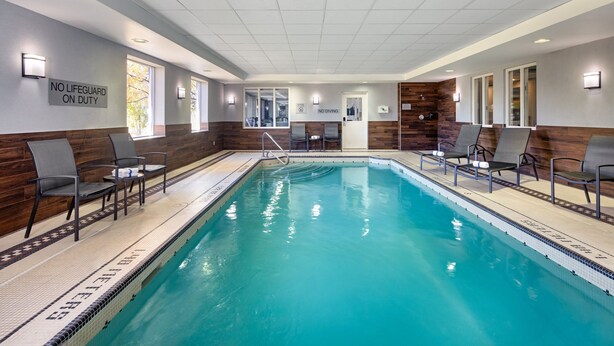 A swimming pool with lounge chairs and a no lifeguard on duty sign. - Fairfield Inn by Marriott Toronto Oakville (Oakville)