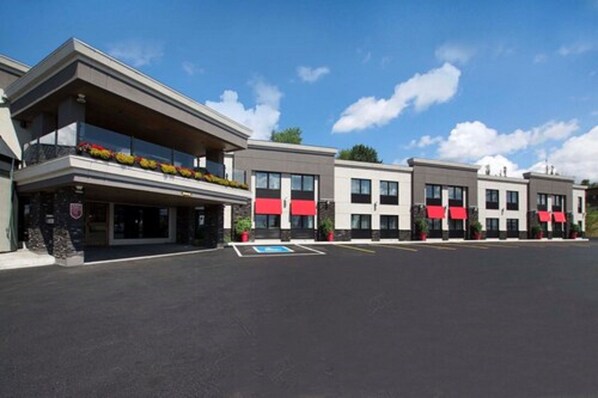 A modern hotel with a flat roof, multiple balconies, and red awnings. - Comfort Inn (Saint Georges)