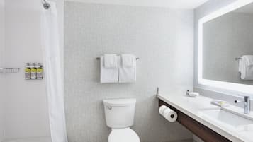 Un baño moderno con ducha, inodoro y lavamanos.